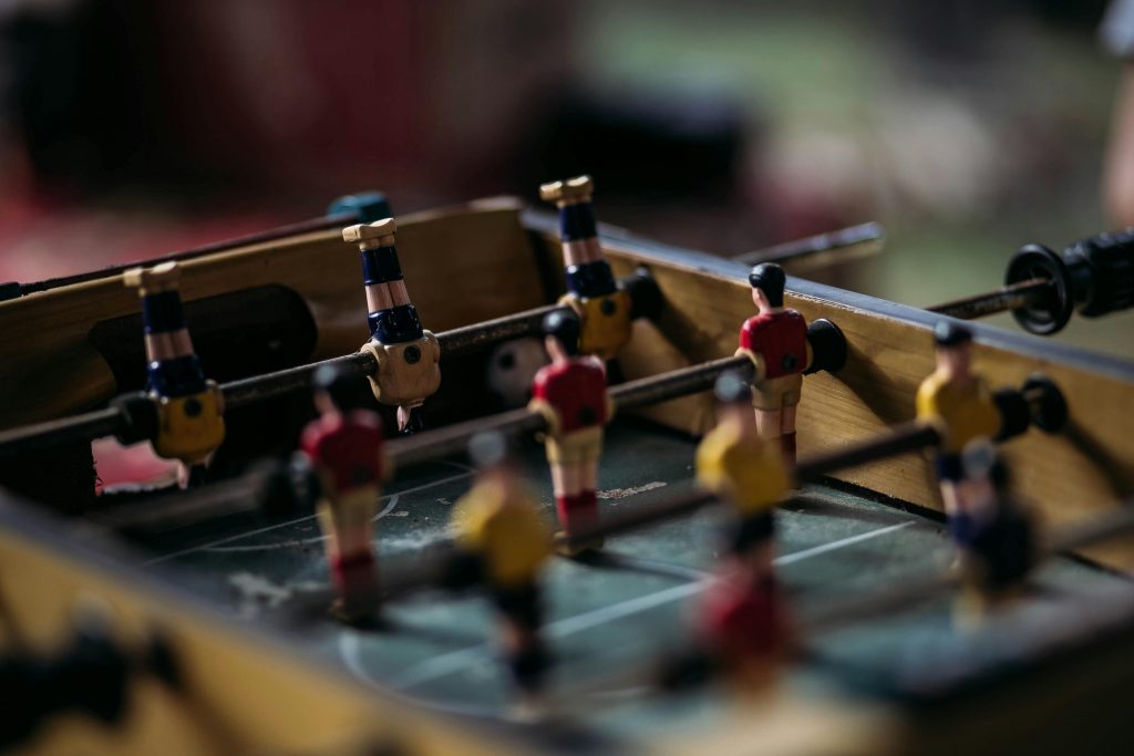 Close-up of a foosball table with miniature soccer players in action.