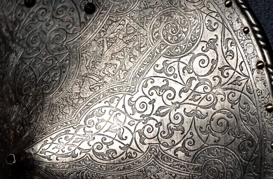 Close-up of a silver shield showcasing detailed ornate patterns and engravings.
