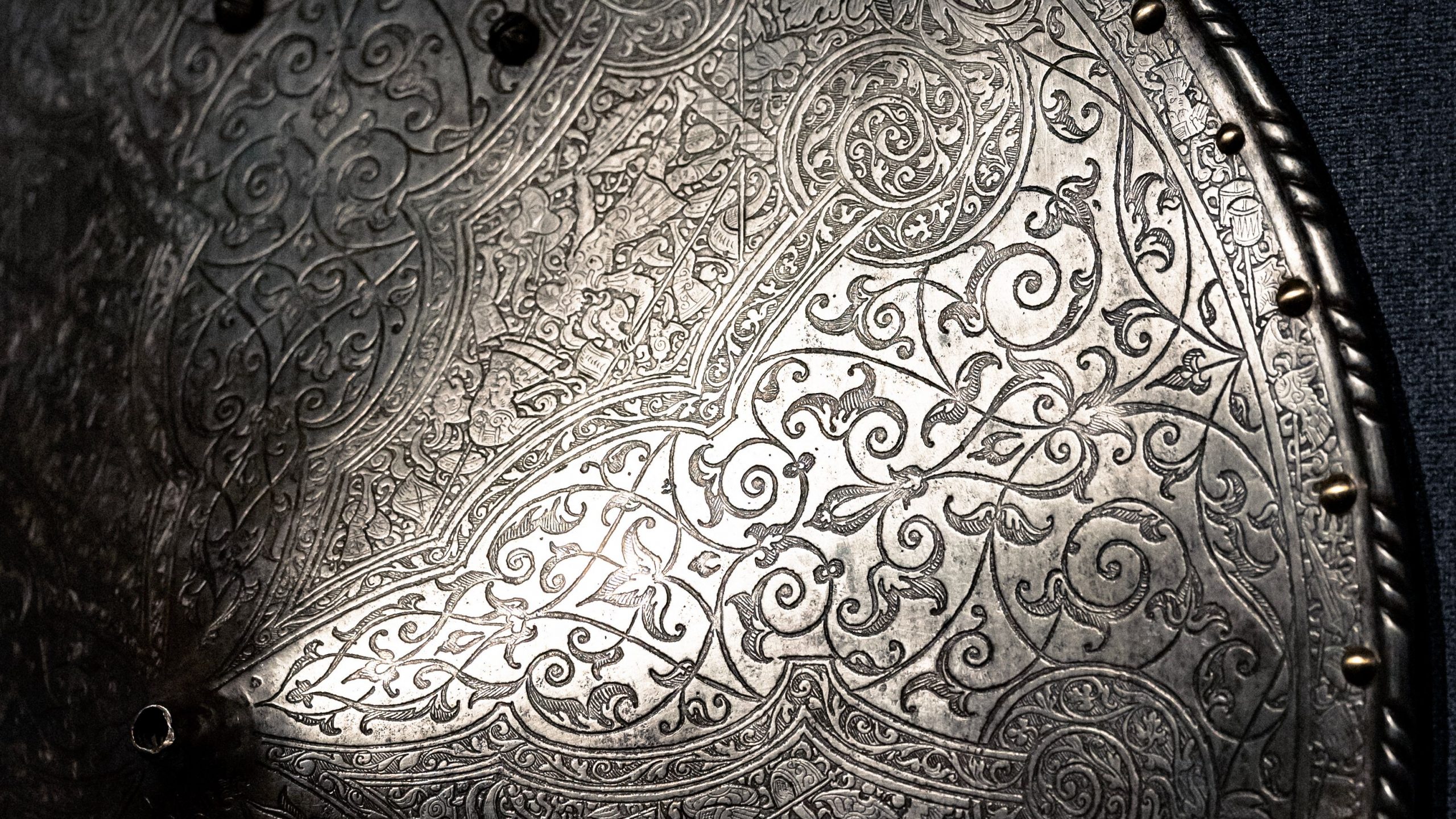 Close-up of a silver shield showcasing detailed ornate patterns and engravings.